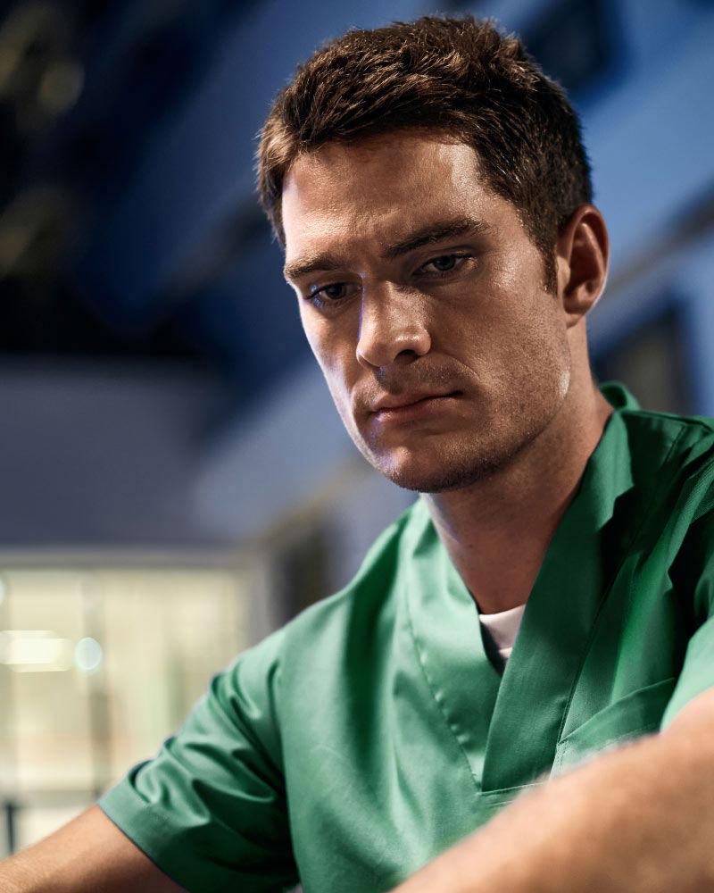 Y tá mệt mỏi ngồi trước bệnh viện