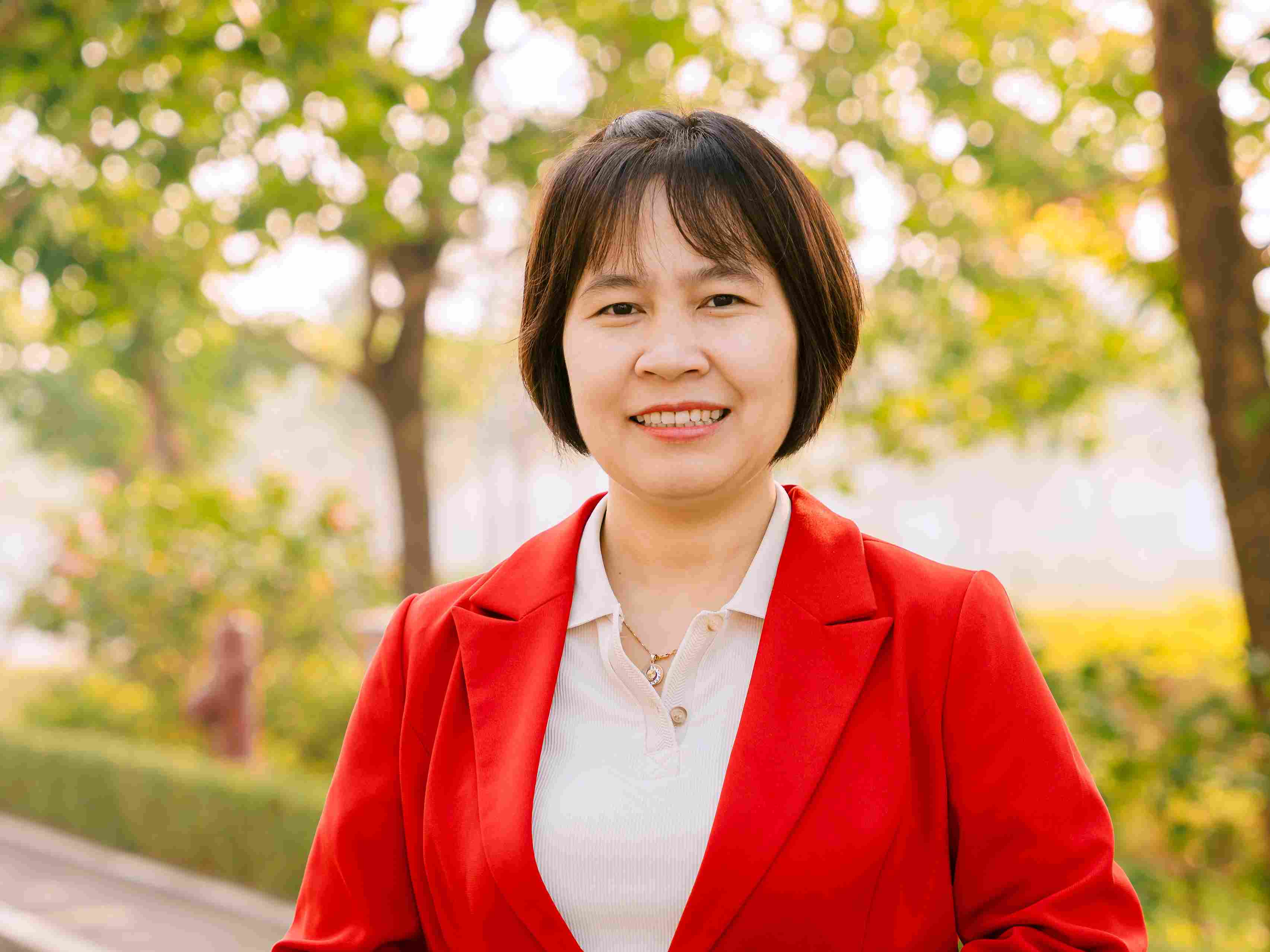 Một cụ bà với nụ cười ấm áp, đứng trong một con hẻm với dáng vẻ duyên dáng. 