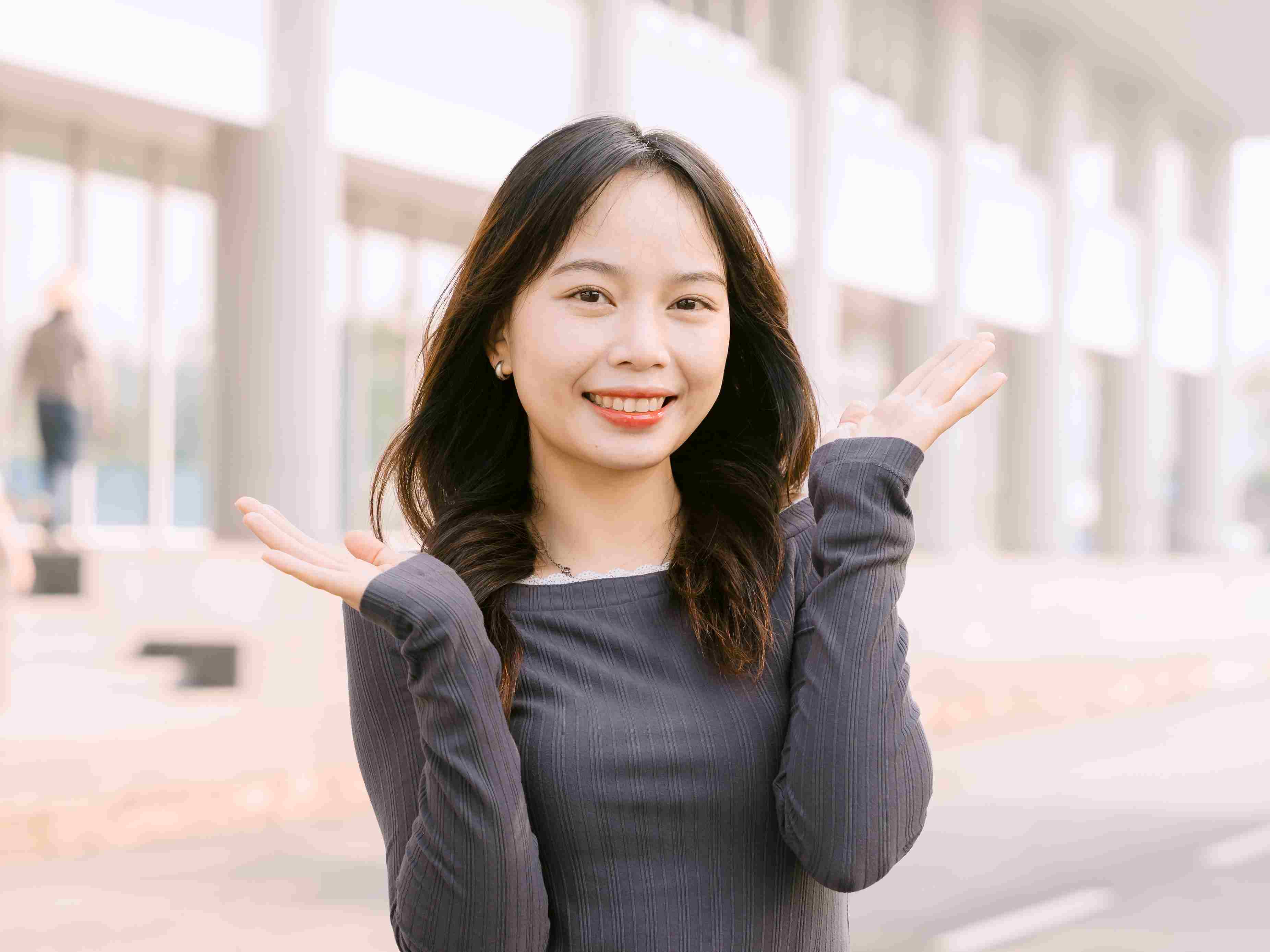 Một người phụ nữ không có tay phải, nhuộm tóc xanh và mang xăm hình đang mỉm cười rạng rỡ và tự tin. 